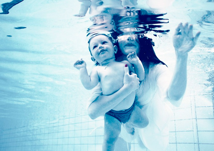 Madre con su bebé en una piscina