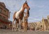 Plaza del Poblado de Oasys Minihollywood con una animadora disfrazada de india acariciando un caballo marrón y blanco.