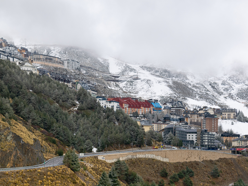 Sierra nevada, en Granada, con casas y nieve y cielo nublado de fondo