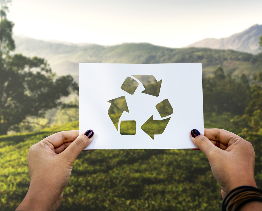 Papel con el símbolo de reciclaje con un fondo de un bosque