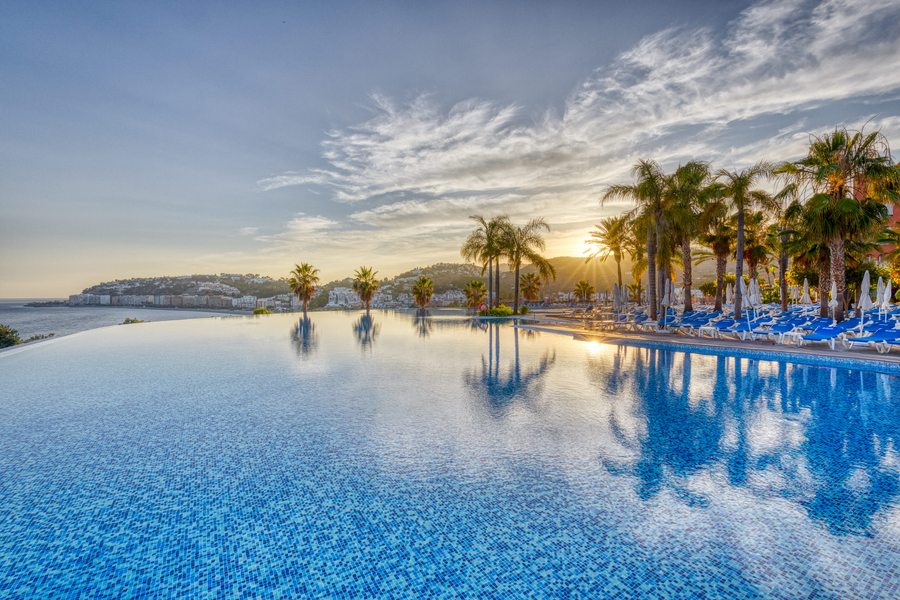 Piscina panorámica de Playacálida Spa Hotel con el mar y palmeras de fondo